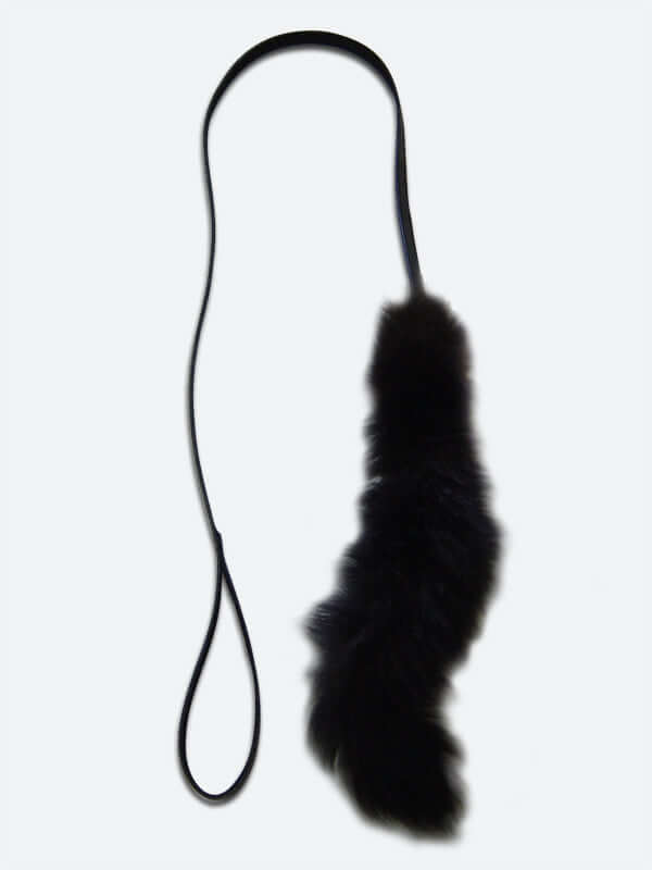 Possum fur tail on a leather strap used for a cat toy